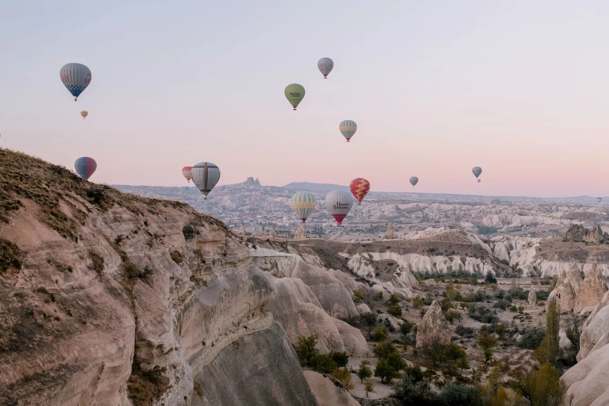 Luchtballonnen bij zonsopkomst boven de rotsformaties van Cappadocië in Turkije